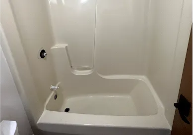 Before shower refinishing showing stained and dull wall tiles